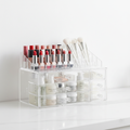 Clear acrylic makeup and skincare organizer with multiple compartments holding beauty products