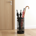 Matte black metal umbrella stand holding several umbrellas near front door