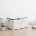 White cable management box hiding power strip and cords in a clean living room setup